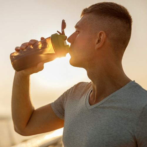 A man drinking water on the sunset