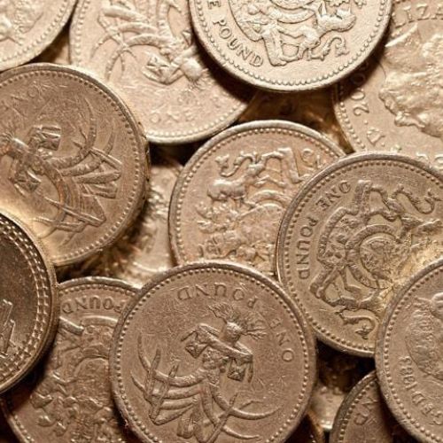 A close-up of a pile of British one-pound coins