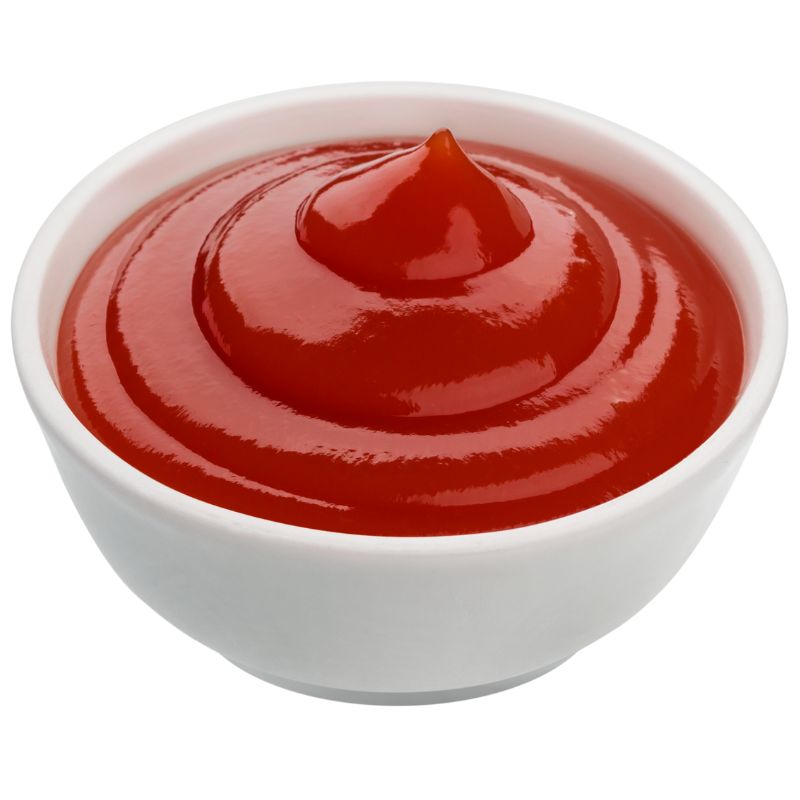 A smooth swirl of bright red tomato ketchup in a small white bowl, emphasising its glossy texture and rich colour.