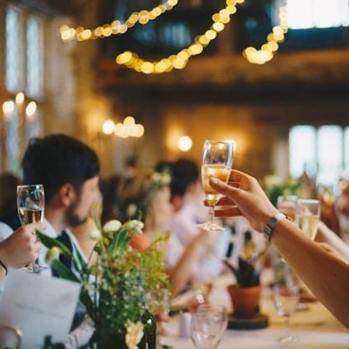 A joyous celebration at a banquet, with a group of people raising their glasses in a toast